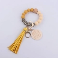 Detail of yellow silicone beads and wooden MAMA tag on the leopard print wristlet keychain - Turmeric