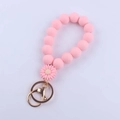 Roze siliconen kralen polsband sleutelhanger met madeliefje bedeltje en gouden sluiting - Roze