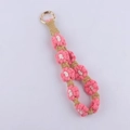 Detail of handmade woven cotton daisy keychain with pink flower pattern and gold ring - Watermelon red
