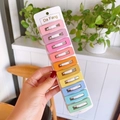 Hand holding a card of 10 colorful square snap hair clips for girls in various pastel shades - Light Candy Colors (Hollow Square Style)