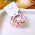 Close-up of translucent pink peach charms on high-elasticity hair ties in a tray - Peach Hair Ties Pair