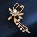 Detailed close-up of a golden flower brooch with shimmering crystals on dark fabric - Flower with Iridescent Center