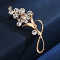 Macro shot of gold floral brooch with sparkling rhinestones on dark blue fabric - Gold Flower