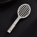 Macro-opname van tennisracket speld met fonkelende strasstenen op getextureerde achtergrond - Zilveren Racket