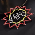 Detailed macro of crystal-encrusted comic bubble HERO brooch with sparkling rhinestones - Explosion English