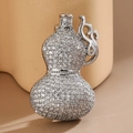 Primer plano detallado de un broche plateado en forma de calabaza con circonitas brillantes - Blanco