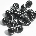 Close-up of black acrylic tennis ball beads with white curved lines for jewelry making - 12mm Tennis Black Background White Line