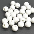 Detailed macro shot of white golf-style acrylic spacer beads on a black textured background - 12mm White Golf