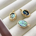 Macro detail of three oval 14k gold-filled abalone shell pendants on velvet tray - 18K Gold Plated Border Abalone Shell