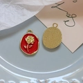 Close-up of red enamel rose pendant with gold relief and pearl accent for DIY jewelry - Red