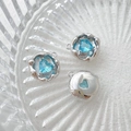 Macro shot of 14k gold-plated heart charms with blue cubic zirconia on glass surface - Silver Base-Blue Heart Gem