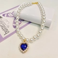 Close-up of pearl pet necklace with blue heart crystal pendant and golden setting - Sapphire Blue