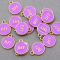 Macro shot of purple enamel round pendants with gold Bff lettering for DIY jewelry - Purple