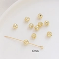 Close-up of 6mm hollow gold-plated brass spacer beads and headpin for DIY jewelry - 6mm / 14K Gold