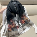 Detailed close-up of a black semi-transparent scarf with floral gold and red embroidery - 70*180cm / Black