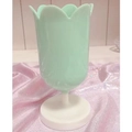 Detailed view of tulip-shaped storage cup in mint green and white on pink sequin fabric - Green