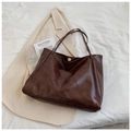 Detailed close-up of dark brown soft leather tote bag with a gold magnetic snap closure - Coffee