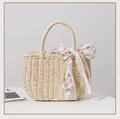Detalle del bolso de paja tejida beige con un lazo de cinta de seda bordada en color rosa - Beige + Cinta Floral