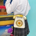 Close-up of a white vintage telephone bag featuring a rotary dial and receiver handle - White