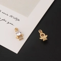 Détail macro de pendentifs ange en plaqué or avec zircons sur une carte blanche - Style Ange 3