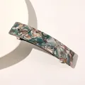 Macro view of long acetate hair clip featuring green marble patterns and silver spring bar - Lake Blue