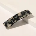 Détail d'une pince à cheveux carrée à motif marbré sur un présentoir minimaliste - Léopard Café Clair