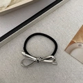 Close-up of a minimalist black elastic hair tie with a polished silver metal bow detail - Alloy Bow Hair Tie