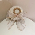 Détail du chouchou en tulle champagne avec nœud à paillettes et bracelet perlé doré - Boucle champagne avec ruban rose
