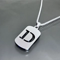 Macro di una collana in acciaio al titanio argento con ciondolo a piastrina e lettera D - Lettera D