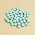 Macro shot of 10mm green polymer clay beads with pink and white spiral stripes for DIY - Hami Melon