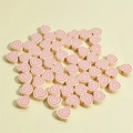 Detailed top view of 10mm pink polymer clay heart beads with colorful concentric patterns - Red