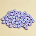 Detailed view of purple heart-shaped clay beads with colorful concentric patterns for DIY - Deep purple