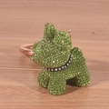 Detailed close-up of a green rhinestone puppy keychain on a wooden surface with bright lighting - Green