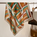 Fashionable square silk scarf with green and orange woven pattern displayed on hanger - 68*68cm / Orange