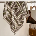 Detailed close-up of a woven pattern silk scarf hanging on a metal hanger for display - 68*68cm / Purple