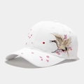 Detalle de grulla bordada y motivos de flores de cerezo en gorra de béisbol de algodón - Ajustable / Blanco