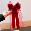 Dettaglio di un grande fiocco per capelli in velluto bordeaux con eleganti nastri velati - Rosso Vino nastro Lungo