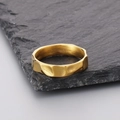 Primer plano detallado de anillo dorado texturizado de acero sobre piedra negra - US 8 / Dorado