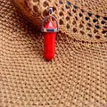 Hexagonal red stone pendant with natural black veins and silver bail on knit background - Red Turquoise