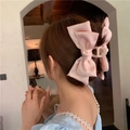 Dettaglio di un grande fermaglio per capelli a fiocco in raso rosa indossato - Rosa