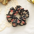 Dettaglio di un elastico per capelli in tessuto con rose rosse e pois viola su nero - Nero