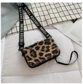 Close-up of leopard print mini suitcase crossbody bag with Forever Young strap on a bed - Leopard Print