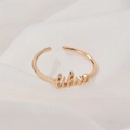 Adjustable golden Libra zodiac sign letter ring for women on white linen background - Libra