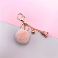 Detail of pink faux fur pompom keychain with golden metal clasp and leather tassel - Pink