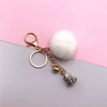 Detail of white faux fur pompom keychain with grey tassel and gold metal hardware - White