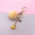 Detail of a beige plush pom pom keychain with gold bell and yellow leather tassel accessory - Beige