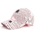 Detail einer hellrosa Baseballkappe mit schwarzem Zeitungsdruck-Muster und gebogenem Rand - Verstellbar / Rosa