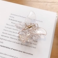 Transparent butterfly hair claw clip with gold spring on vintage book page background - Pink