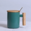 Dark green ceramic mug featuring a wooden handle, matching lid, and a gold spoon accessory - Cylindrical Green Mug with Lid & Spoon