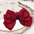 Elegant wine red satin bow hair clip with layered fabric on a vintage mirror - Burgundy
